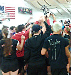 Spring Lake fans and players alike celebrate Thursday night with the district title trophy after the Lakers defeated Whitehall in five grueling sets. Photo/Steve Gunn