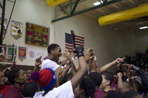 Muskegon students hoist Deshawn Thrower on their shoulders after the senior guard's 28 point performance. Photo/Jason Goorman 