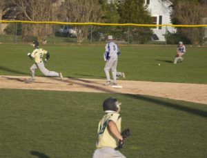 Nick Holt drives a single to left as Anthony Woodard rounds second for MCC. Photo/Jason Goorman