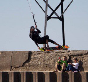 Local kiteboarding legend Marc Hoeksema catches air during KOGL 2013 as Chris Bobryk and his mother sit along the Grand Haven pier. Photo/Samuel Goorman
