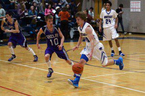 Monatuge's Jake Buchberger dribbles the ball up the court with Shelby's No. 10 Caleb Anderson following. Photo/Steve Gunn