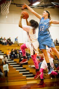 Muskegon #11 Tasheyanna Wyrick drives to the hoop while Mona Shores #12 Kelsey Wolffis skies for the block photo/Tim Reilly
