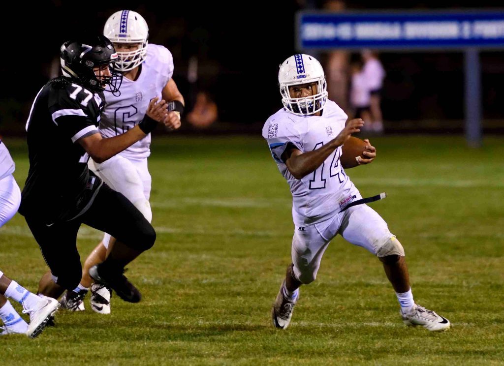 Mona Shores’ Dee Davis (14) runs for a first down to the outside. Photo/Eric Sturr