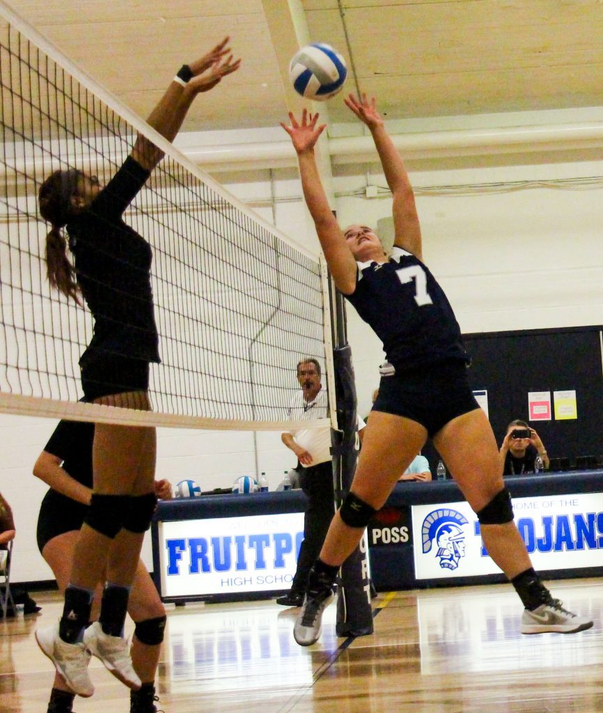 Fruitport's No. 6 Katie Veihl gives a quick set while Mona Shores' Justice Porter-Harris tries for the block. Photo/Jason Goorman