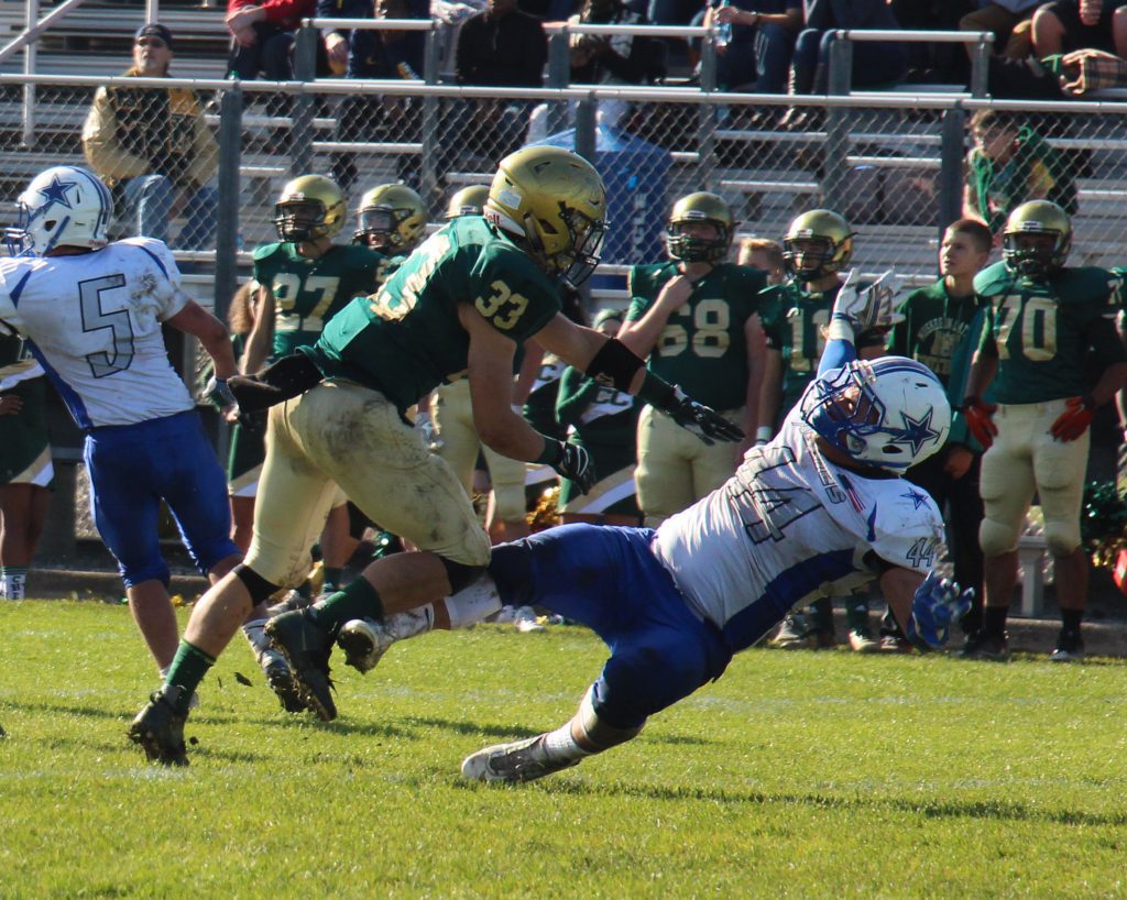 MCC's No. 33 Andrew Schulte sends No. 44 Brett Upton flying after the pass. Photo/Jason Goorman