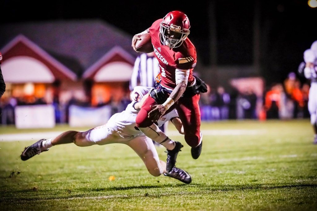 Muskegon's Kalil Pimpleton flies through the air for the Big Red gain against Byron Center. Photo/Tim Reilly